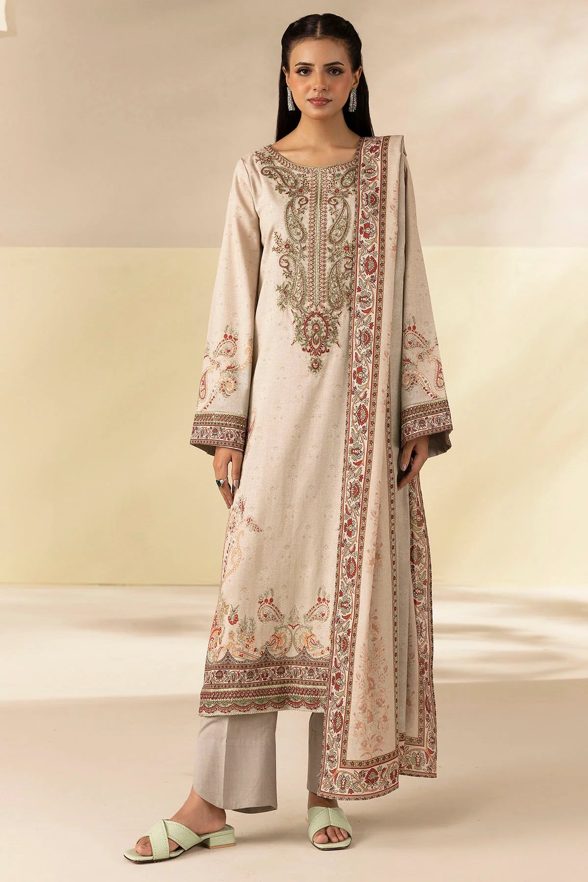 Woman wearing a traditional outfit with intricate embroidery on a plain background