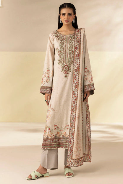 Woman wearing a traditional outfit with intricate embroidery on a plain background
