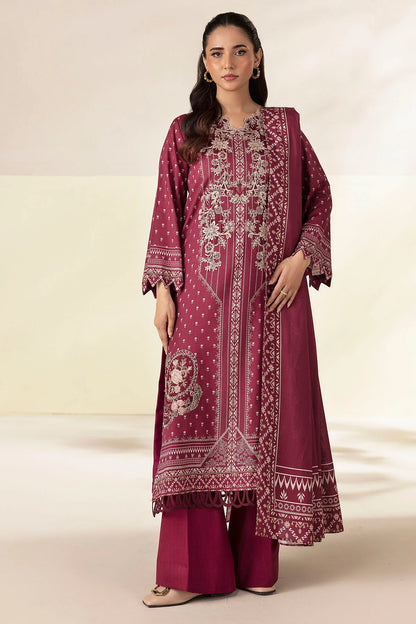 Woman wearing a maroon embroidered traditional outfit on a beige background