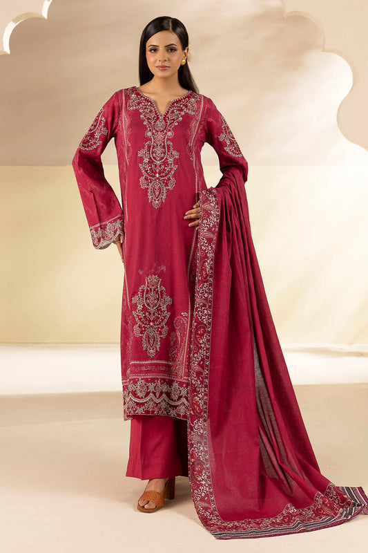 Woman wearing a maroon embroidered traditional outfit with a matching dupatta on a beige background