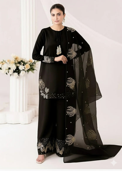 Woman wearing a black traditional outfit with floral patterns on a white background