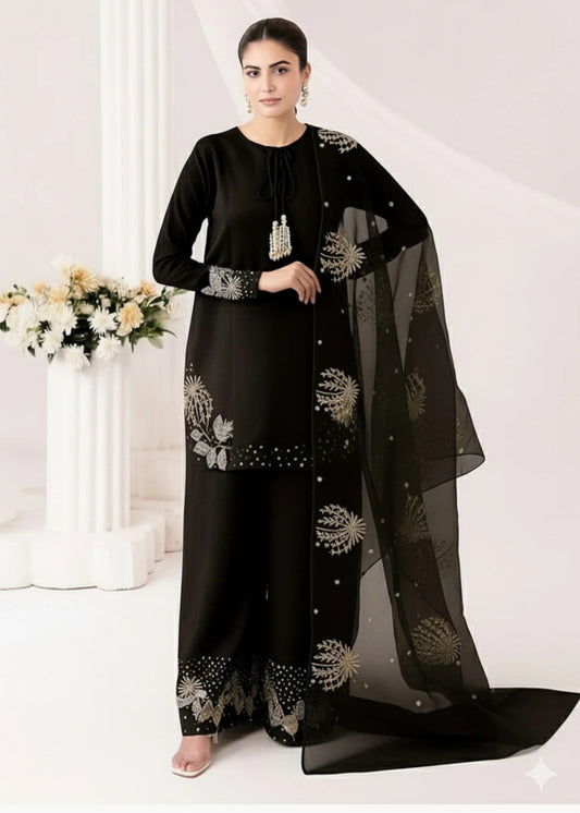Woman wearing a black traditional outfit with floral patterns on a white background
